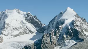 Corvatsch mountain - a snowy mountain tops with blue sky.