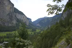 A town surrounded by mountains with small waterfalls. This is a picture of Lauterbrunnen.