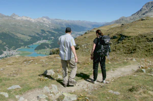 Two hikers enjoying a scenic mountain trail, surrounded by breathtaking views of nature's beauty.