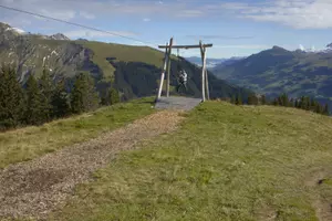 A man swinging on a zip line at the Vogellisi playground on the top of a mountain.